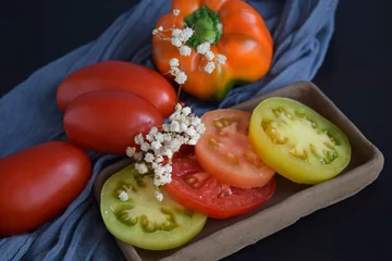 Tragetasche Rijpe tomaten op een zwarte achtergrond.Heerlijk vegetarisch eten. © NADEZHDA