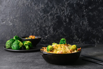 Frying pan with tasty rice and vegetables on dark background