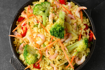 Frying pan with tasty rice and vegetables on table, closeup