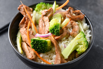 Bowl with tasty fried rice on dark background, closeup