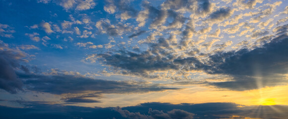 Naklejka na ściany i meble Panorama shining of the sun through the beautiful clouds of the setting sun