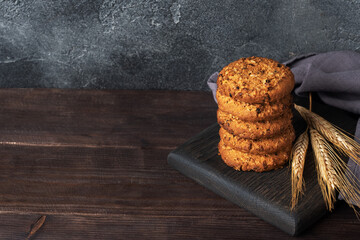 Homemade cookies with cereals and seeds. Oatmeal crackers on a wooden background. Copy space.