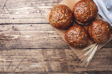 Bread products with cereals and seeds on a wooden background. Lean healthy buns, carbohydrate pastries. Copy space