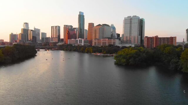 Cinematic shot of austin texas, with people enjoying the lake, and a bird flying majestically across the screen.