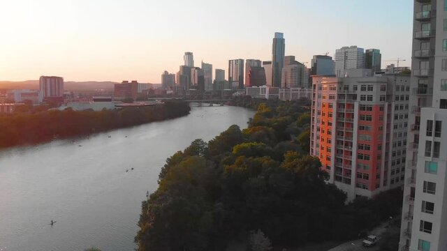 View of downtown Austin Texas from the end of Rainey Street. Drone shot at sunset in August 2020