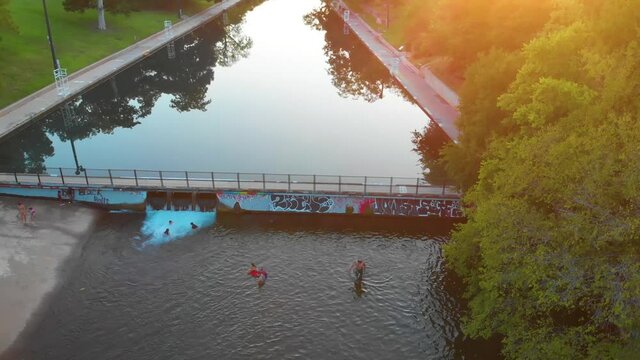 Dynamic moving shot of barton springs pool and barton creek. People and dogs being active in the foreground. August 2020