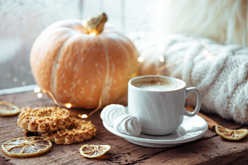  A cup of coffee, cookies and pumpkin on the windowsill. Autumn concept