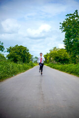 Young asian / Indian boy running on the road