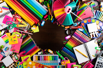 School supplies. Set of colorful school accessories isolated on the brown table. Top view.