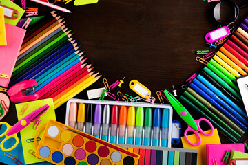 School supplies. Set of colorful school accessories isolated on the brown table. Top view.