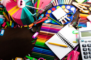 School supplies. Set of colorful school accessories isolated on the brown table. Top view.