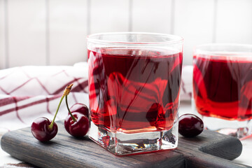 Cherry juice in glass glasses with fresh cherry berries. White background. copy space.