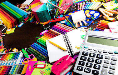 School supplies. Set of colorful school accessories isolated on the brown table. Top view.