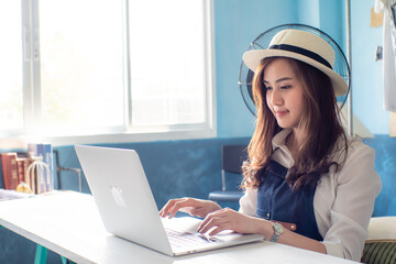 Successful happy girl manager in her own office working with laptop