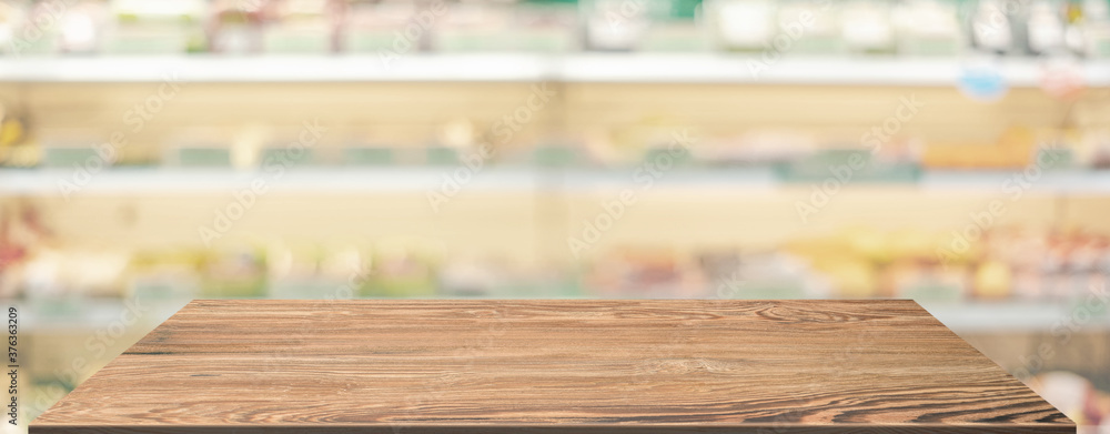 Poster empty wood table top food stand with blur grocery product shelf background bokeh light,mockup for di