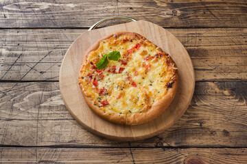 Homemade pizza tortilla with tomato and cheese on wooden background. Copy space