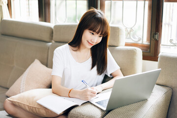 Asian teenager woman work and study online via internet at home.