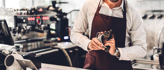 Portrait of bearded barista man small business owner working with laptop computer behind the...