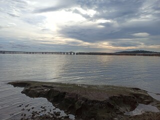 Beach view at sunset with cloudy sky