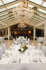 Close up of festive tables setting with wine glasses, and fresh flowers