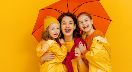 Family with umbrella on colored background.