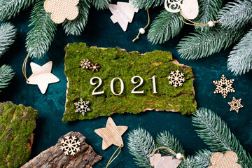 Happy new year 2021. Wooden Christmas or new year decorations on the branches of the tree. Christmas background with wooden numbers 2021. Eco decorations