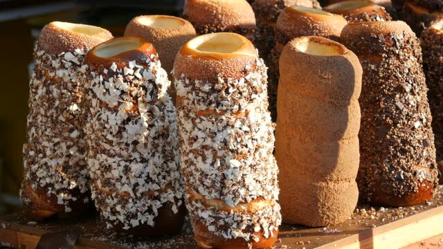 Czech national pastry Trdelnik bun with various sprinkles at the street food festival.