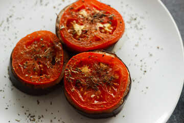 Baked eggplant with tomatoes. Eggplant on a plate. Delicious hot dish