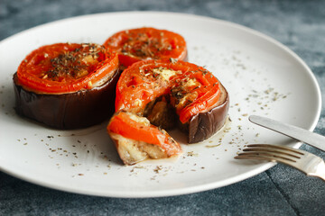 Baked eggplant with tomatoes. Eggplant on a plate. Delicious hot dish