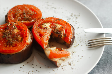 Baked eggplant with tomatoes. Eggplant on a plate. Delicious hot dish