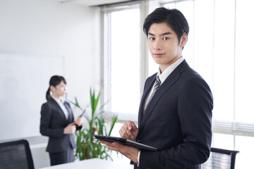 オフィスで笑顔で迎える日本人男性ビジネスマン