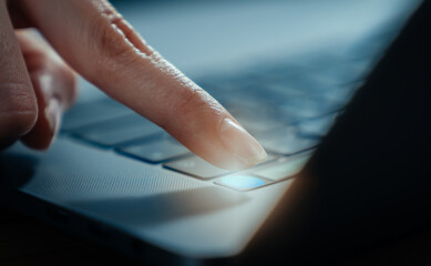 Hands touch fingerprint on the laptop screen scanner to access personal user online.