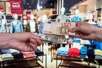 man pays for purchases in a clothing store