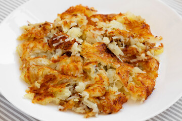 Homemade Fried Hashbrowns on a white plate, low angle view. Close-up.