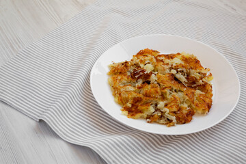 Homemade Fried Hashbrowns on a white plate, low angle view. Copy space.