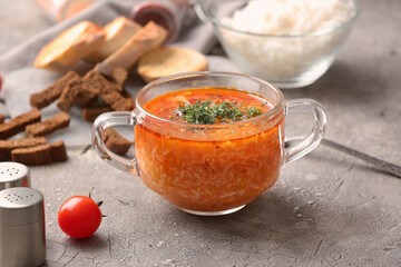 Pot of tasty rice soup on grey background