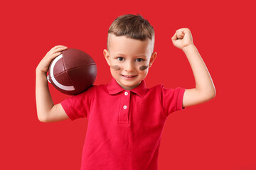 Little boy with rugby ball on color background