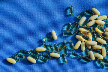 Transparent tablet capsule on blue background with shadows.