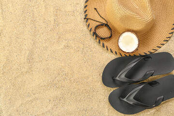 Fototapeta na wymiar Male hat with flip-flops and coconut on sand