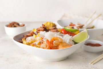 Bowl with tasty rice noodles on table