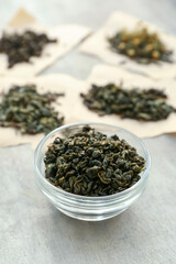 Bowl with dry tea leaves on table