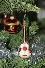 Weihnachtsdekoration auf dem Tannenbaum. Eine rote Glaskugel mit goldene und grüne Motive und eine...