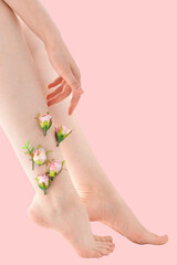 Woman's thin unshaven leg with pink flowers on a pink background. Feminism