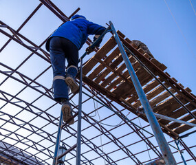 A worker rises to install a metal canopy.