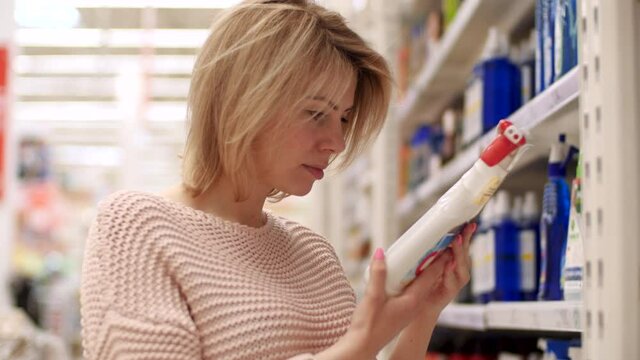 One 30s Confident Women Buyer Look Picking Household Chemicals Shelf Indoor Store. Handsome Girl Focused Searching Sold Bio Bottle Essentials. Holding in Hands Analize Select in Department Closeup 4k