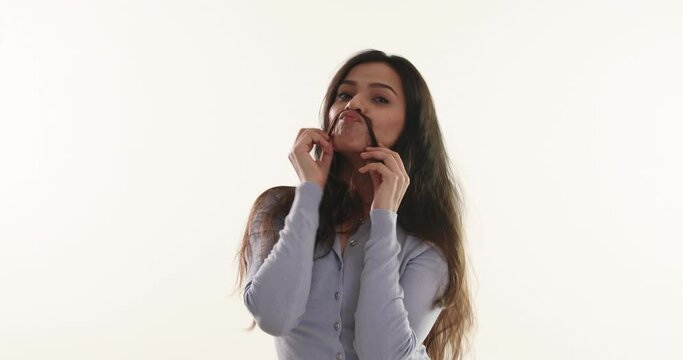 Young woman making a fake moustache with her hair	