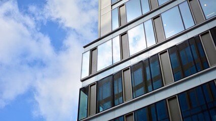 Obraz premium Office building, blue glass wall reflection detail. Modern office building and clear sky background. 