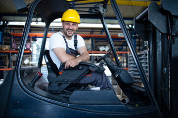 Portrait of professional forklift driver in factory's warehouse.