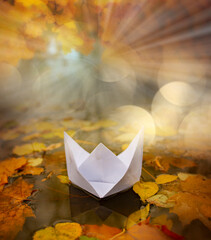 paper boat on an autumn river close up