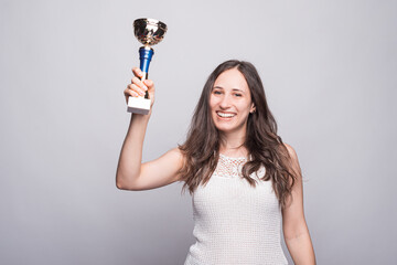 Photo of happy young woman celebrating and holding Champion Cup and looking confident at camera